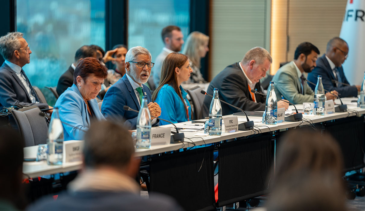 Attendees from various countries listening to a presentation a conference room