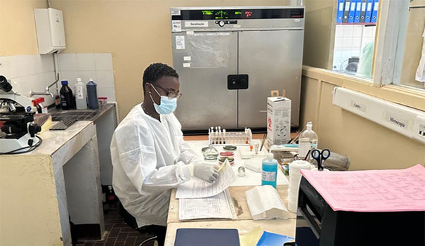 A researcher wearing a mask reading analysis results in a laboratory.
